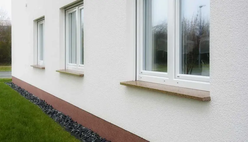 Eleganckie parapety kamienne w ciepłych kolorach dodają uroku białej elewacji.