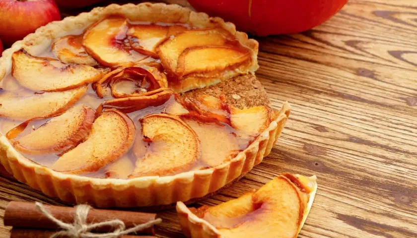 Deliziosa crostata con mele caramellate e cannella, un classico tra i dolci con mele, pronta per essere gustata.