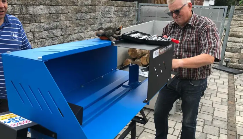 Mann mit Holzspalter Güde GHS 370/4TE, bereit, Holz zu spalten.