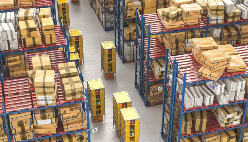 Duże magazynowe zapasy towarów na regałach i paletach. Automatyczne wózki transportują towary między rzędami.