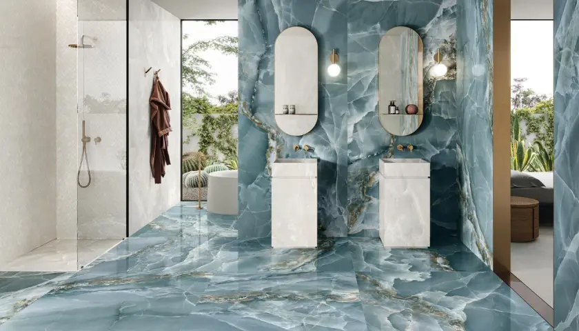 Bagno di lusso con pavimenti e pareti in diversi tipi di gres porcellanato effetto marmo blu e bianco.