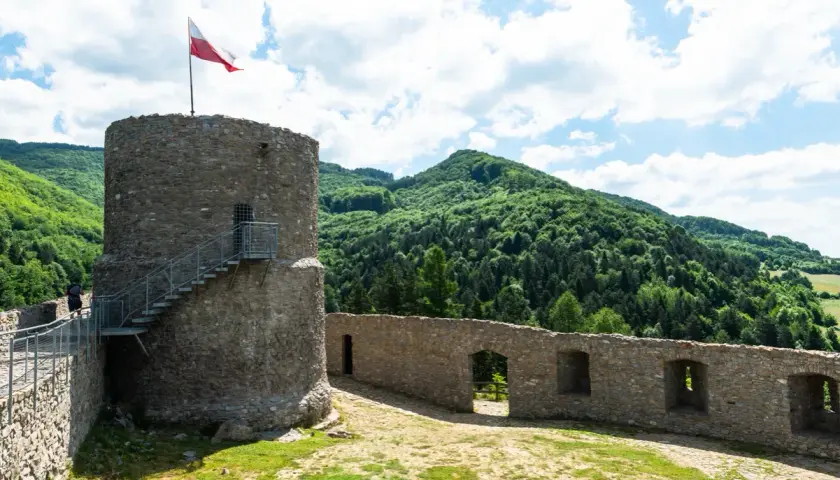 Kamienna wieża z polską flagą i malownicze wzgórza. Rytro atrakcje zachwycają widokami i historią.