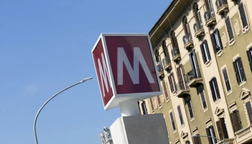 Segnale della metro con la "M" rossa su sfondo bianco, vicino a un palazzo storico. Baldo degli Ubaldi metro.