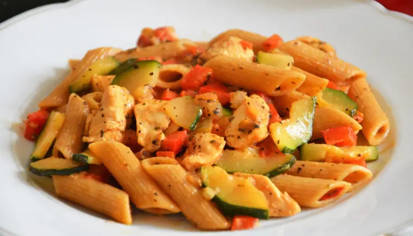 Penne z kurczakiem, cukinią i pomidorami w sosie. Pyszne dania z makaronem ryżowym i kurczakiem.