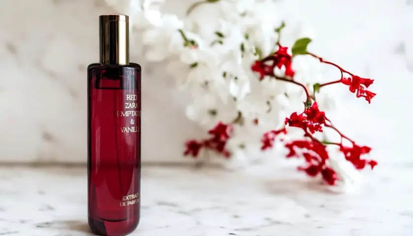 Elegancka butelka perfum Zara Red Temptation & Vanille, idealny odpowiednik dla miłośniczek zmysłowych zapachów, na tle delikatnych kwiatów.