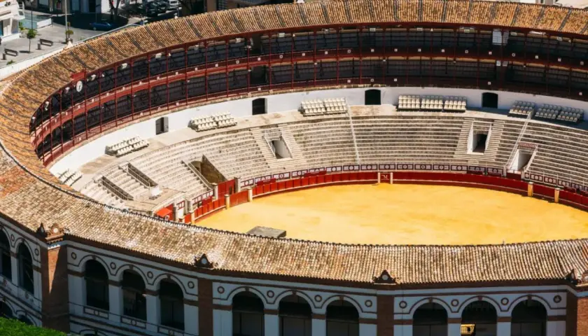 Vista aérea de la plaza de toros de Ronda, con sus gradas vacías y la arena dorada. El aforo de la plaza de toros de Ronda es impresionante.