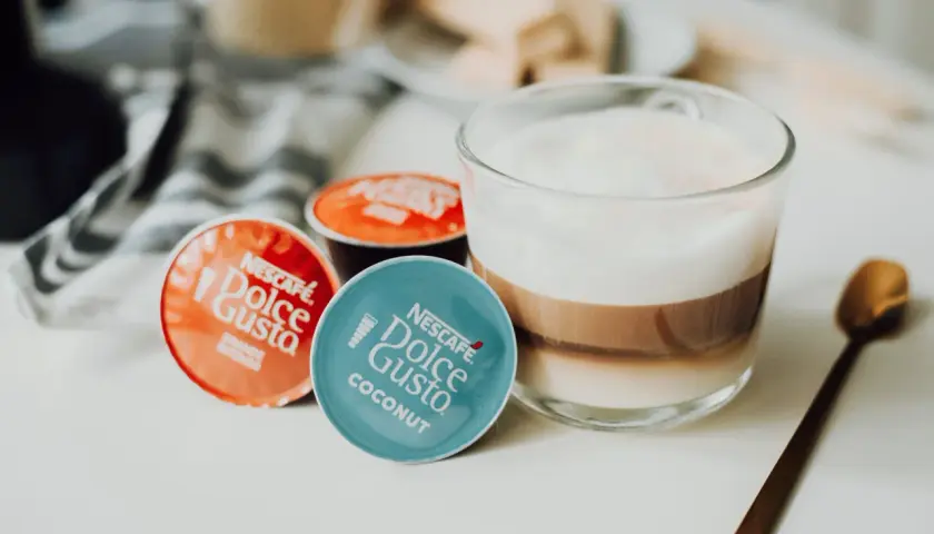 Kapsułki Dolce Gusto obok kawy z mlekiem. Może ekspres Dolce Gusto nie chce wyjąć kapsułki?