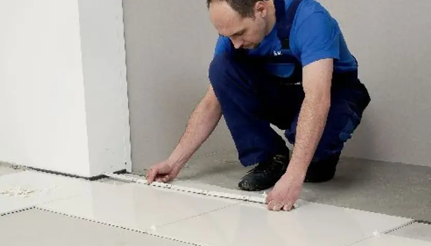 Fachowiec układa płytki 60x60, dbając o równe fugi. Wzory układania płytek są kluczowe dla estetyki.
