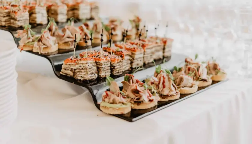 Petits fours variés sur un plateau noir, parfaits pour un mariage avec un budget alcool maîtrisé.