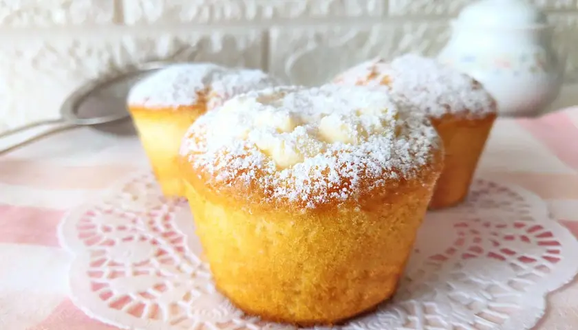 Tre muffin soffici, spolverati di zucchero a velo, perfetti per una ricetta muffin semplici e golosa.