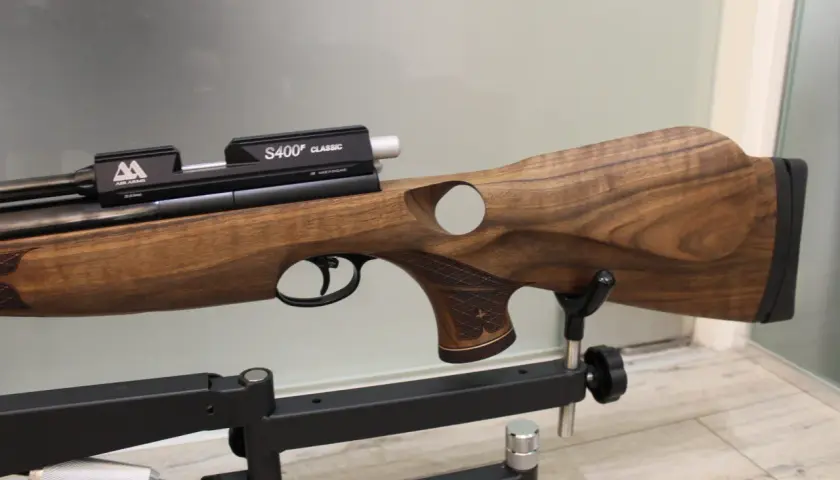 Elegancki karabin pneumatyczny Air Arms S510 z drewnianą osadą, prezentowany na statywie.