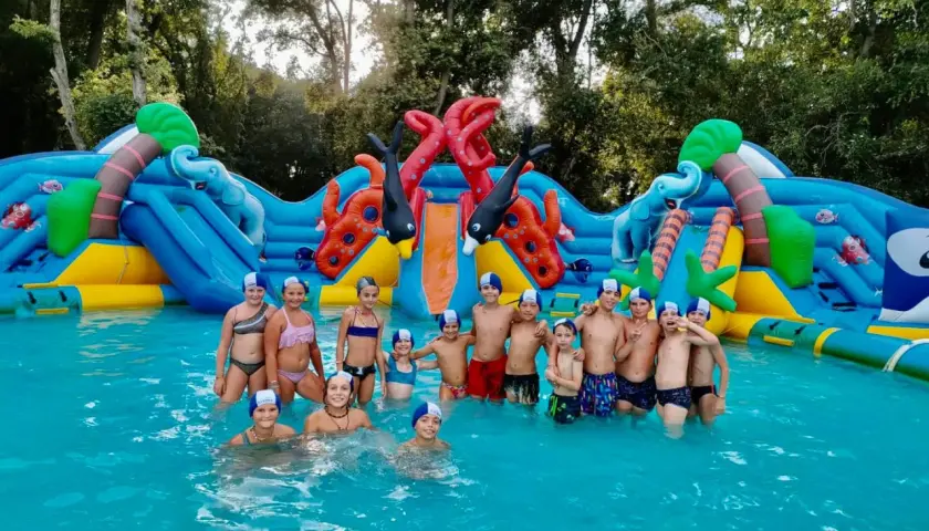 Bambini felici in un parco acquatico gonfiabile, un'avventura indimenticabile per il loro campo estivo.