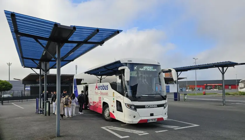 Autobus Aerobus na przystanku lotniskowym, z pasażerami wsiadającymi.