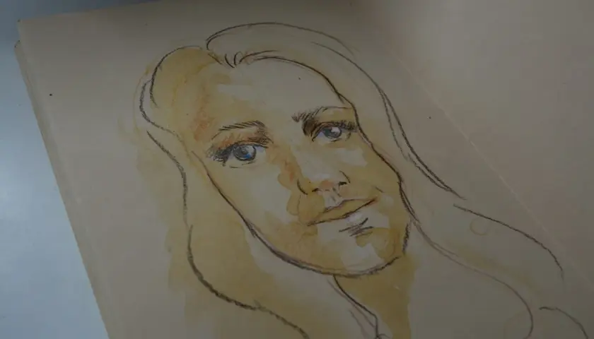 Szkic kobiety z niebieskimi oczami i blond włosami. To może być autoportret, uchwycony w delikatnych barwach.