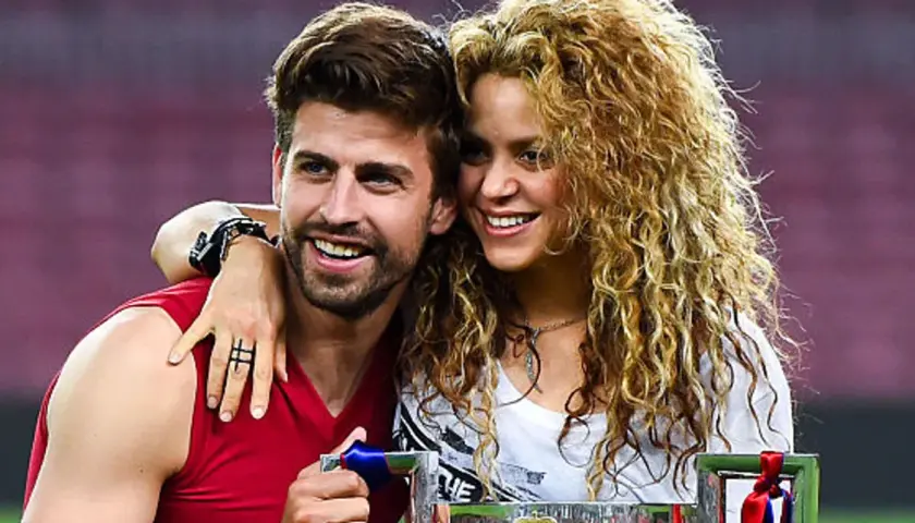 Shakira i Piqué świętują sukces. Uśmiechnięci, blisko siebie, z pucharem w rękach.