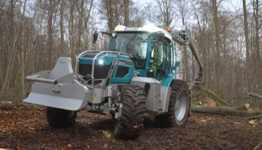 Ein moderner **Traktor mit Kran** im Wald, bereit für die Holzernte.