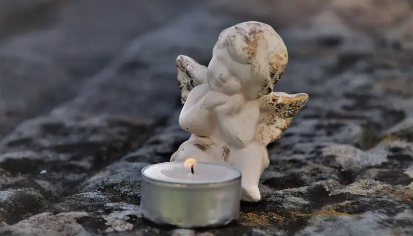 Aniołek czuwa przy płonącej świecy, symbolizując żałobę po cioci.