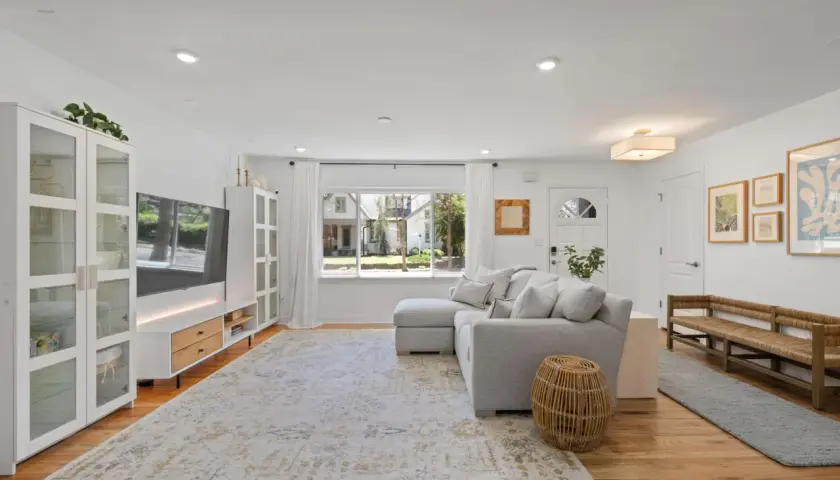 A bright living room with a sectional sofa, TV, and a large rug. This rug is made of polypropylene, so do polypropylene rugs get hot in the sun?