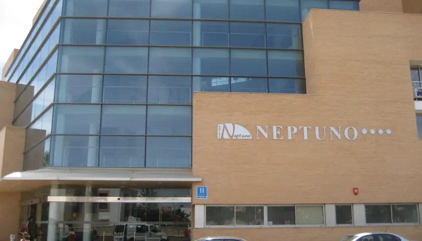 Fachada moderna del hotel Neptuno Roquetas de Mar, con amplios ventanales y detalles en ladrillo.