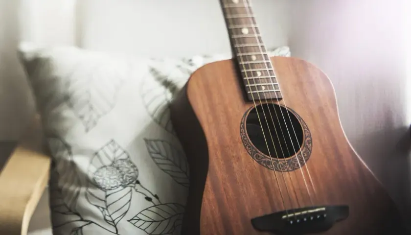 Akustyczna gitara na poduszce z liśćmi. Idealna do nauki pastorałka od serca do ucha akordy.