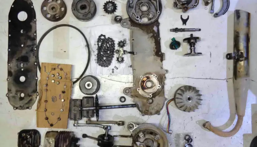 Despiece de una moto: carcasa, cadena, engranajes, cigüeñal, pistón, ventilador, escape y otras partes.
