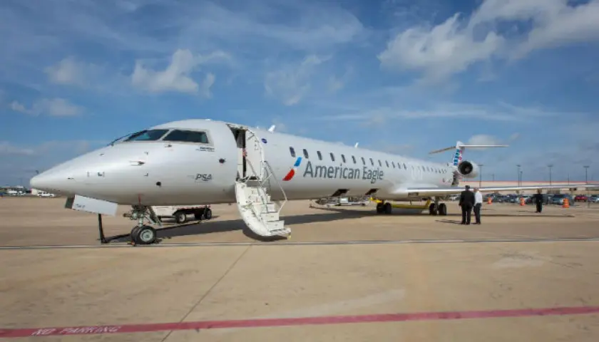 Samolot Canadair Regional Jet 900 linii American Eagle z otwartymi schodami na płycie lotniska.