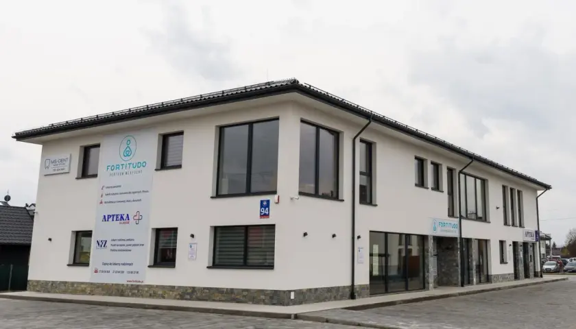 Nowoczesny budynek z szyldami "Fortitudo Centrum Medyczne", "MS-DENT" i "APTEKA".