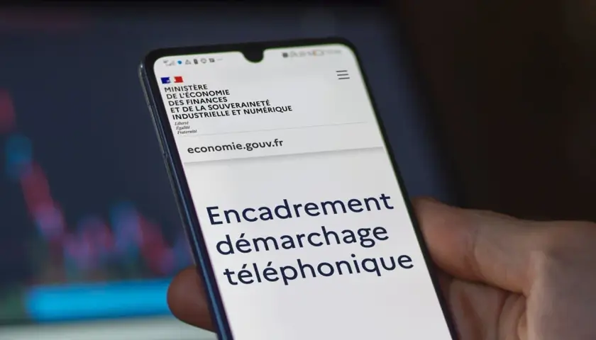 Un smartphone affiche le site du Ministère de l'Économie, avec le titre "Encadrement démarchage téléphonique".