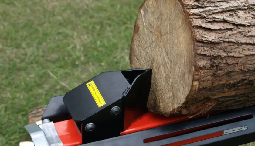 Ein Holzstamm wartet auf den benzin holzspalter, um ihn zu spalten.