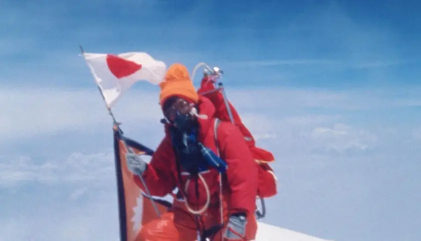 Junko Tabei mit japanischer Flagge auf dem Gipfel des Mount Everest.