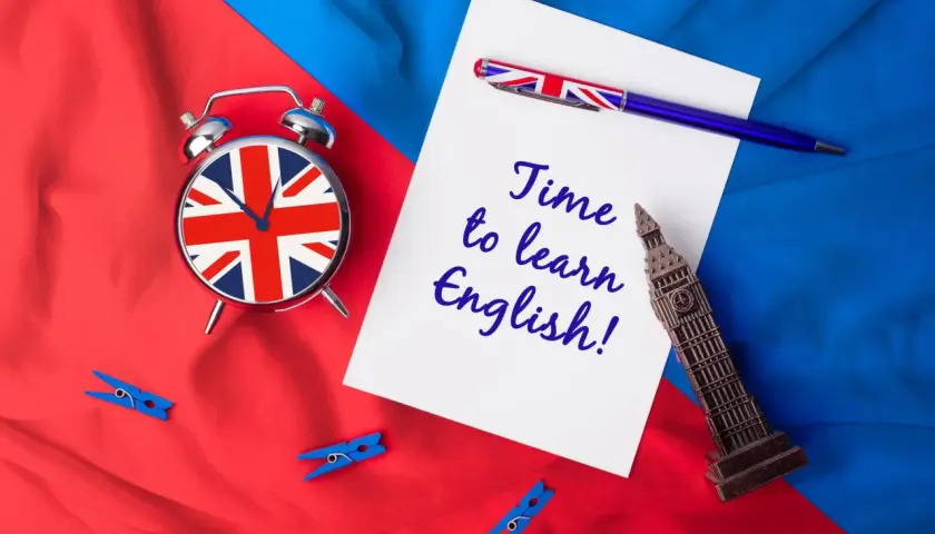 Budzik z flagą Wielkiej Brytanii, długopis i napis "Time to learn English!" na tle brytyjskich barw. Sebastian, czas na naukę!