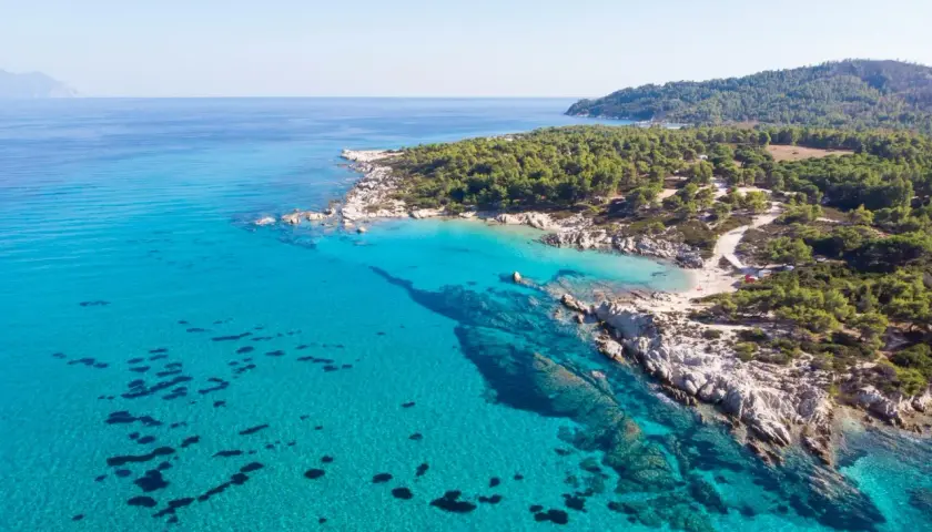 Turcja egejska: turkusowe morze obmywa skaliste wybrzeże z sosnowym lasem. Idealne miejsce na wakacje.