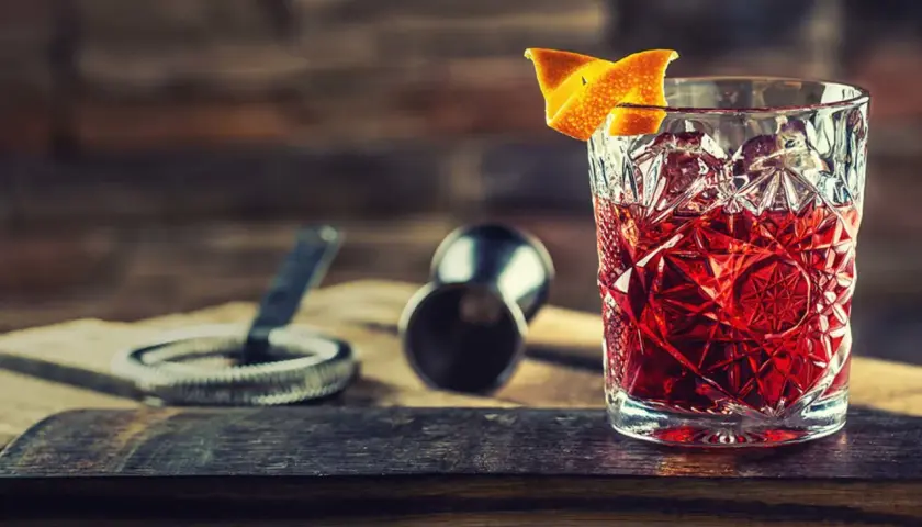 En klassisk negroni drink med apelsinskal, redo att avnjutas.