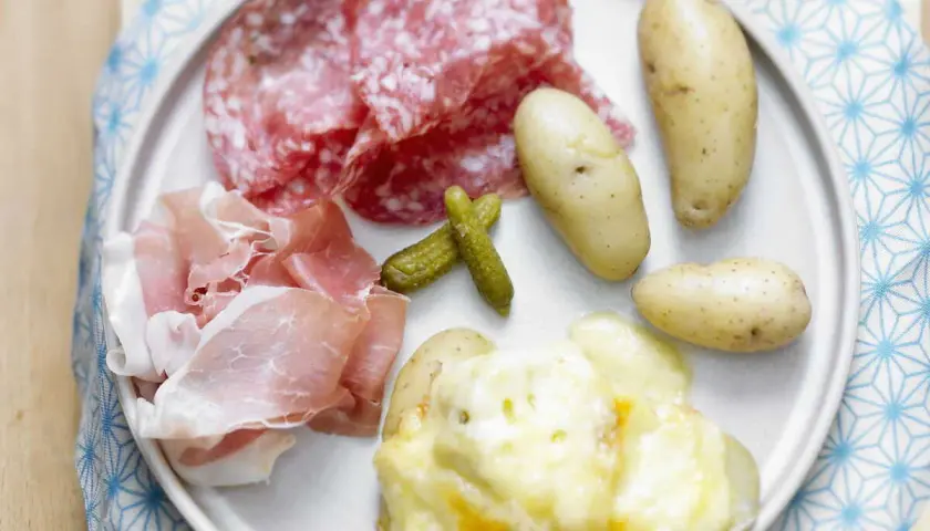 Assiette de raclette sans appareil : pommes de terre gratinées, charcuterie, cornichons. Un délice !