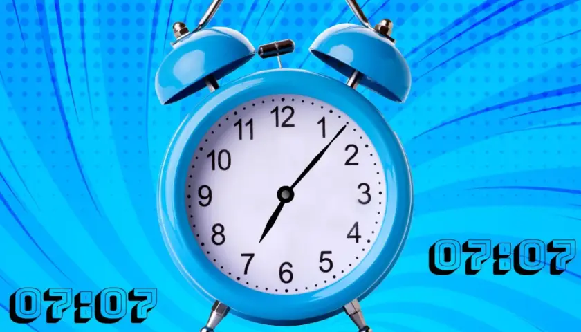 Reloj despertador azul con la hora espejo 07:07. El tiempo se detiene en este momento especial.