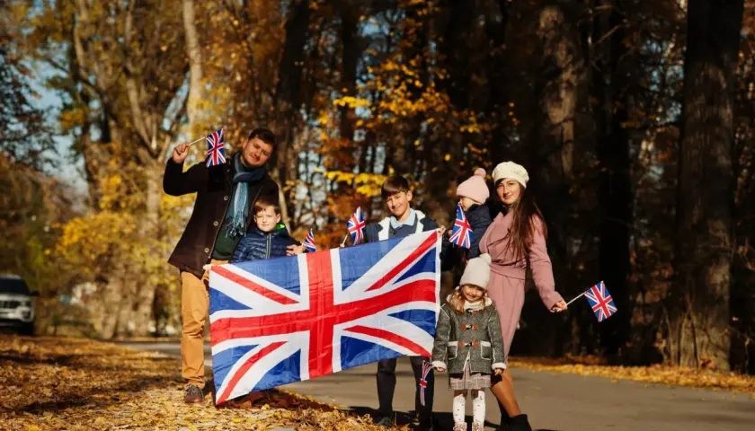 Moja rodzina po angielsku, dumna z brytyjskich korzeni, pozuje z Union Jackiem na tle jesiennych liści.