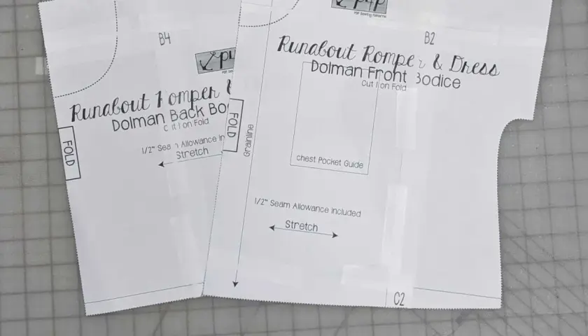Close-up of a DIY romper pattern for a "Runabout Romper & Dress," showing front and back bodice pieces with instructions like "Cut 1 on Fold" and "Stretch.