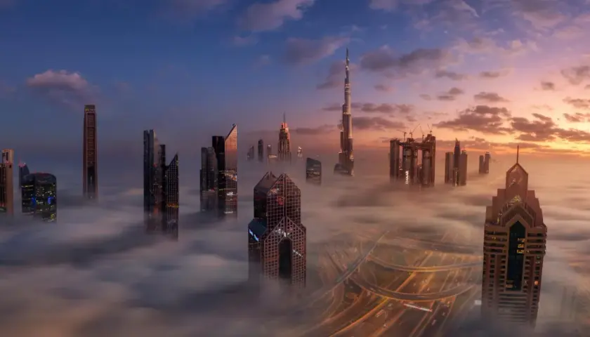 Wieżowce w chmurach, gdzie jest największy budynek na świecie. Wschód słońca nad Dubajem.