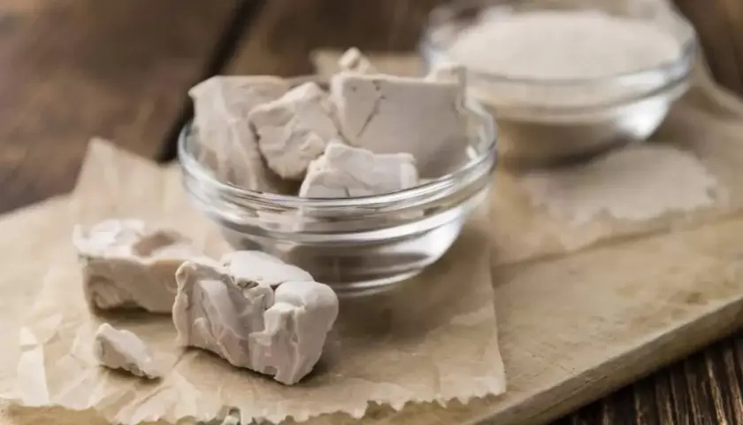 Blocs de levure fraîche périmée dans un bol en verre, prêts à être jetés. À côté, une autre coupelle contient de la levure sèche.