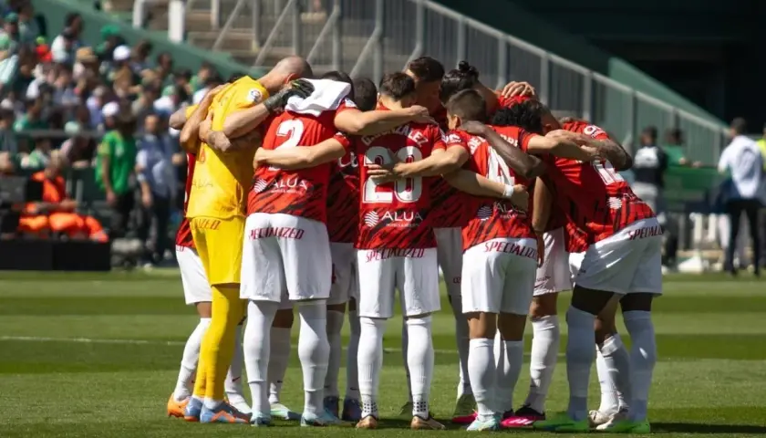 Piłkarze RCD Mallorca w czerwonych strojach tworzą zwarty krąg przed meczem z Valencią CF.