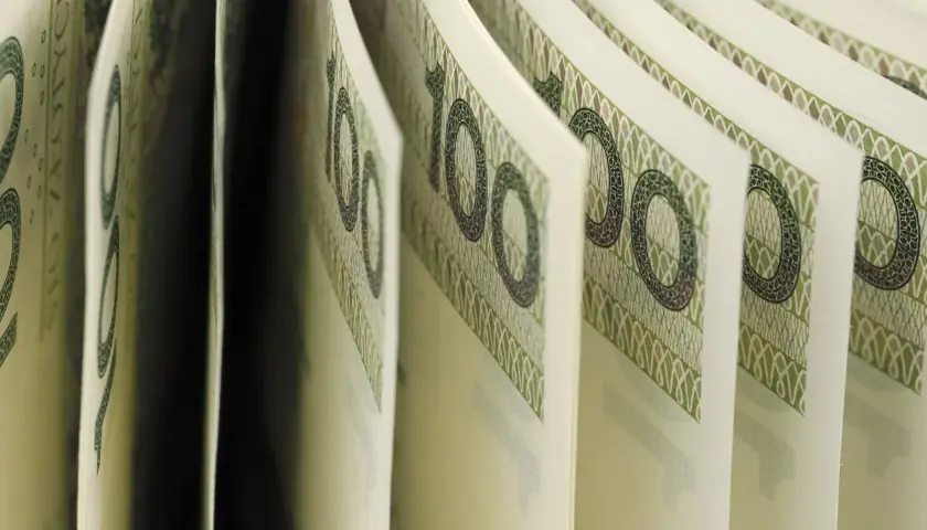 Złote banknoty 100 zł, symbolizujące przyszłe dochody i nadzieję na wyższą kwotę wolną od podatku 2026.