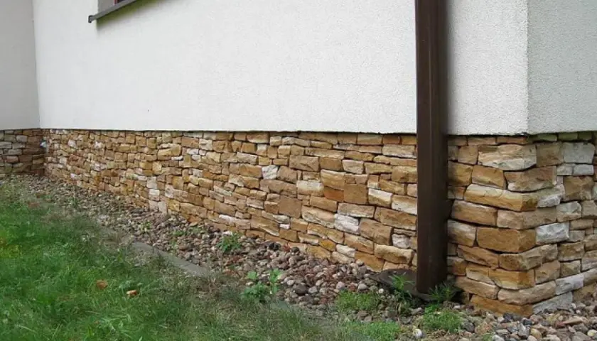 Kamienny cokół domu, ozdobiony naturalnym kamieniem, chroni ściany i dodaje uroku.
