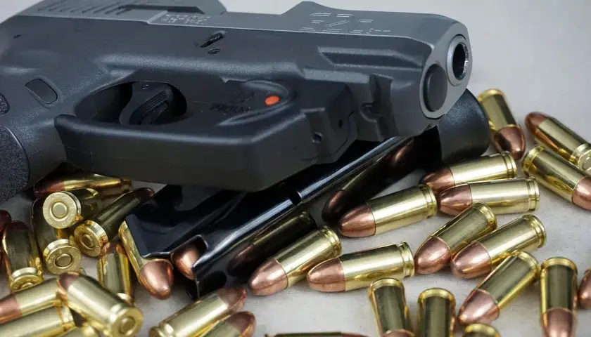 Pistolet i magazynki otoczone nabojami. Różne rodzaje pistoletów mogą być prezentowane w podobnych ujęciach.