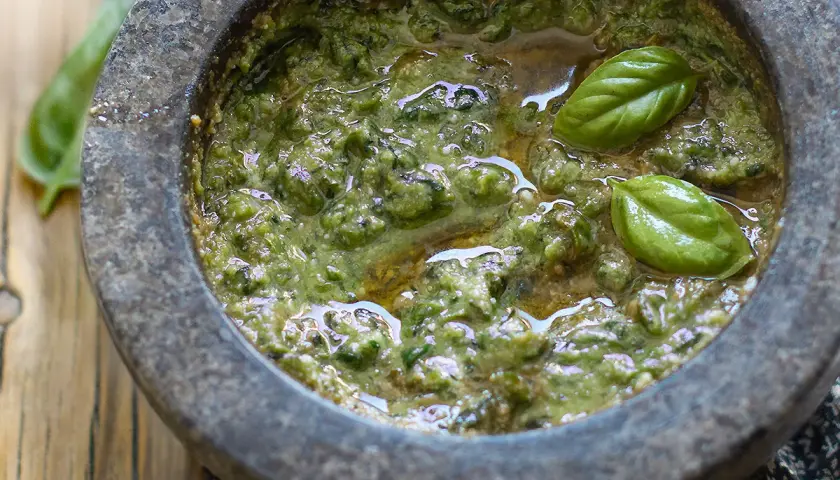Pesto genovese originale appena fatto nel mortaio, con basilico fresco e olio d'oliva.