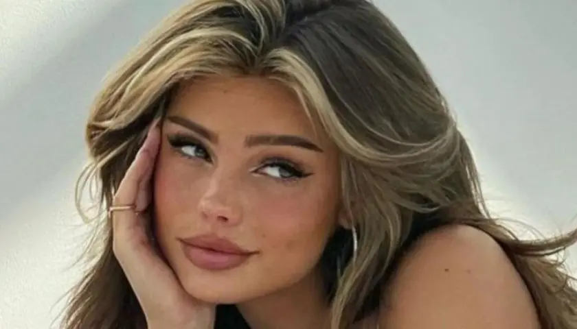 Primer plano de una joven con cabello castaño y reflejos rubios, con sus baby hairs peinados hacia atrás.