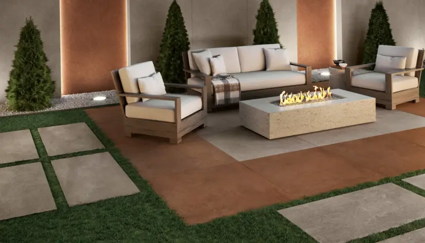 Elegante soggiorno esterno con divano, poltrone e tavolino con fuoco. Il pavimento per balcone in gres porcellanato effetto pietra crea un'atmosfera accogliente.