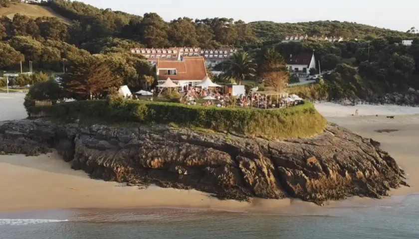 Evento en la playa madre Cantabria, con gente disfrutando de la terraza y el ambiente festivo, quizás antes de unos conciertos.