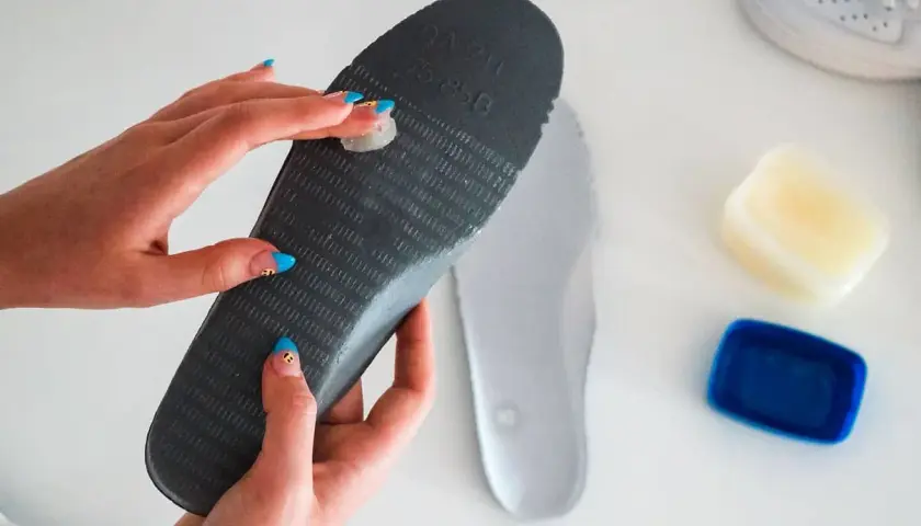 Applying balm to an insole to stop slides from squeaking.