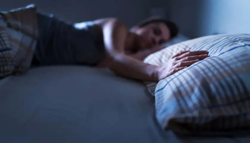 Persona durmiendo, mano sobre almohada. ¿Qué significa soñar con tu padre fallecido?