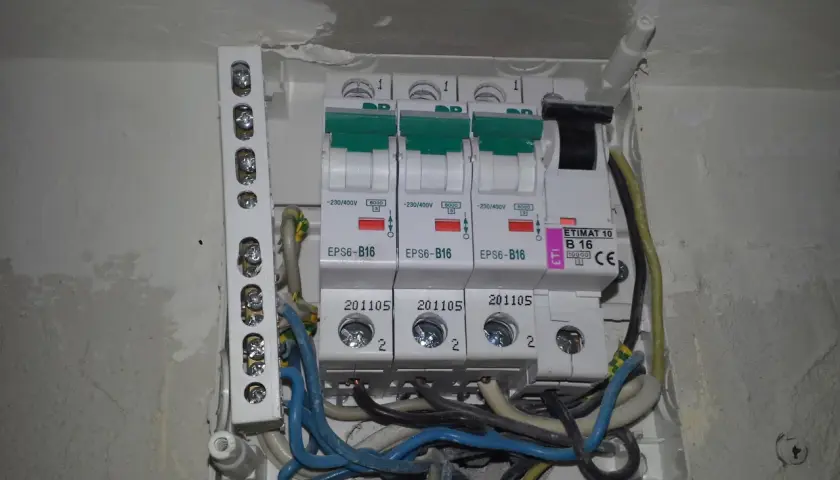 Widok z bliska na skrzynkę z bezpiecznikami i przewodami elektrycznymi.